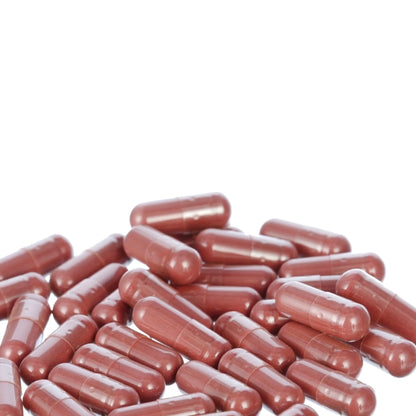 a pile of red capsules or pills scattered on a white background.