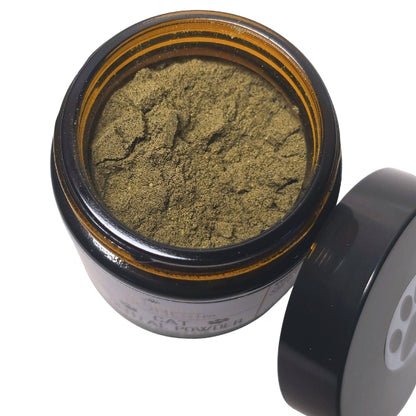 A jar of green powder is shown, with the lid partially open, revealing the contents inside.